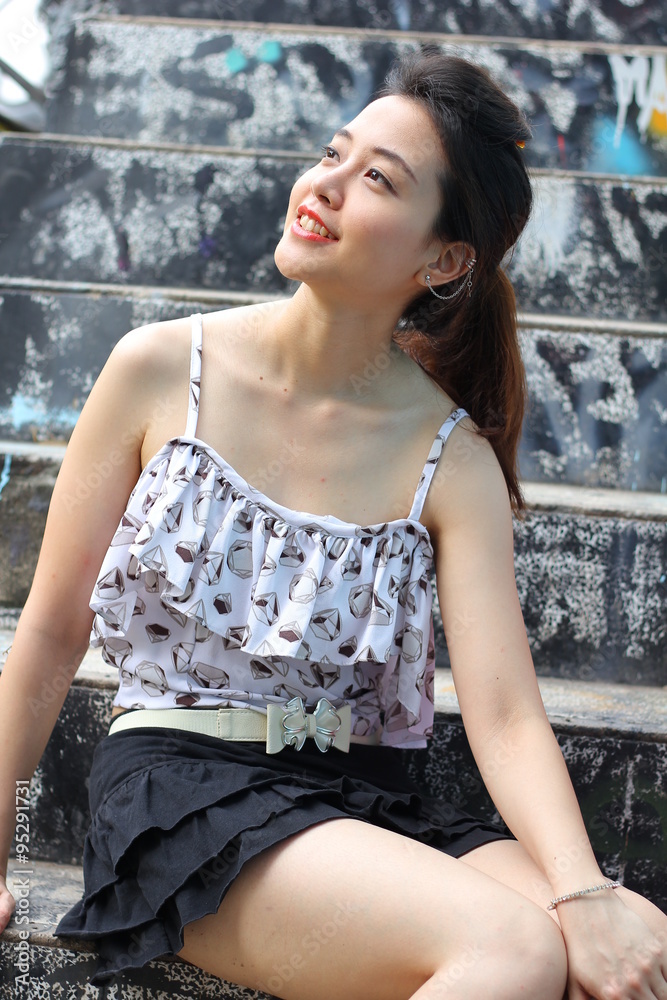 Fototapeta premium Portrait of thai adult beautiful girl relax and smile on graffiti wall 