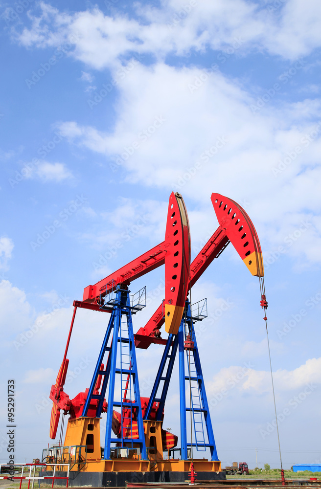 The oil pump, under the blue sky white clouds The oil pump, under the blue sky white clouds