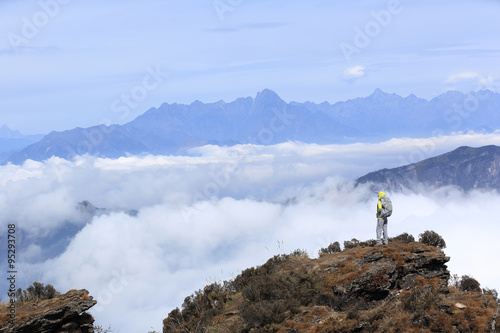  young woman hiker on beautiful rolling clouds mountain peak