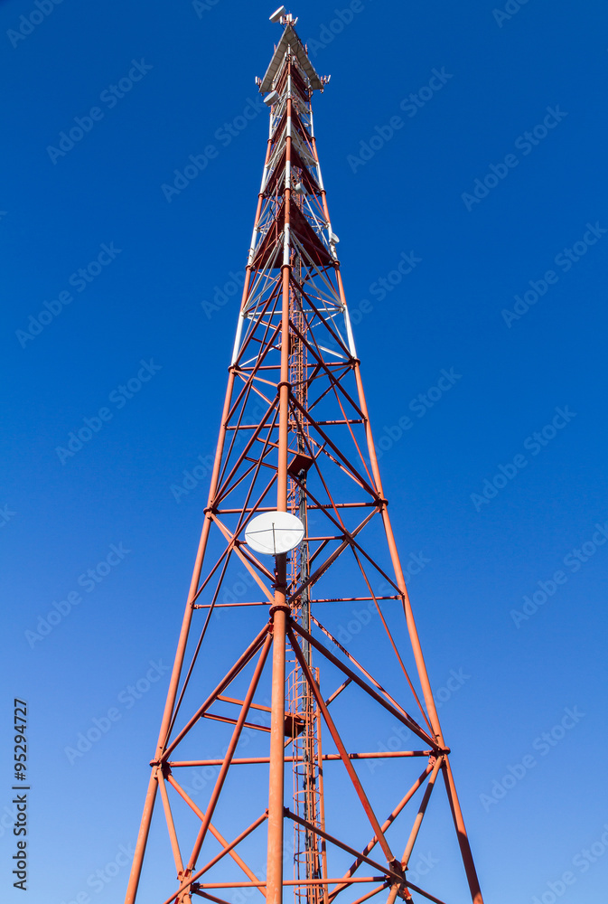 Telecommunication mast TV antennas on blue sky background . Telecommunication mast TV antennas on blue sky background .