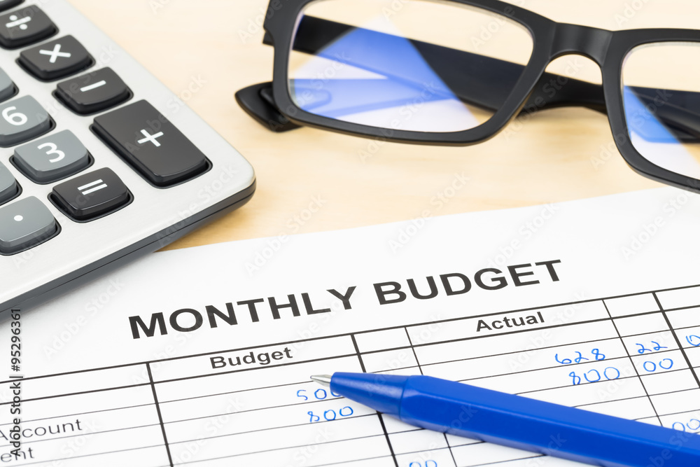 Home budget planning sheet with pen, glasses, and calculator Home budget planning sheet with pen, glasses, and calculator
