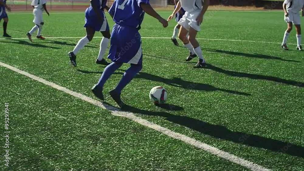 A soccer player dribbles down the field during a game
