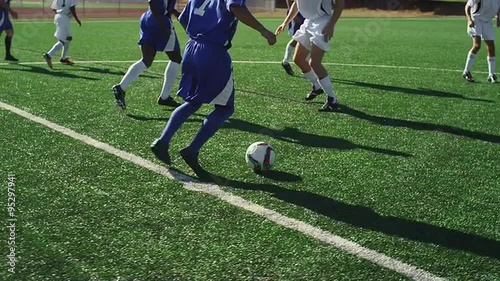 A soccer player dribbles down the field during a game
