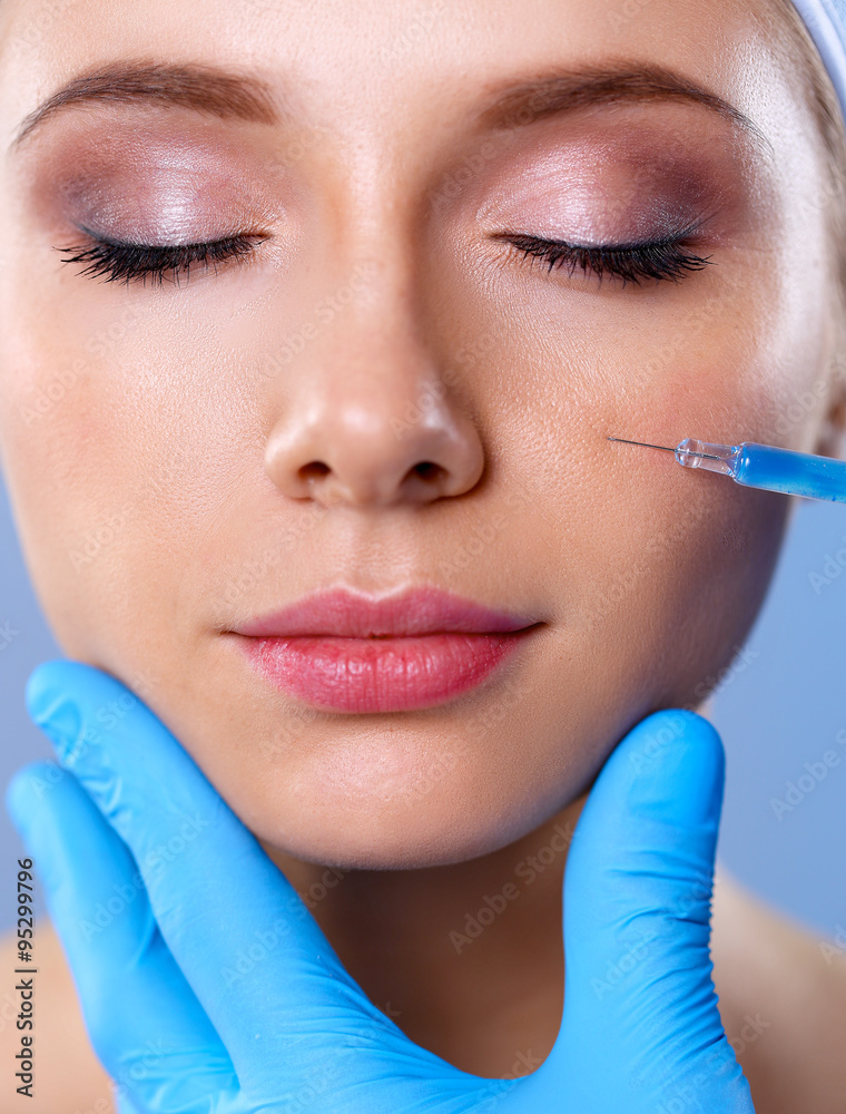 Cosmetic injection on the pretty woman face. Isolated on gray background