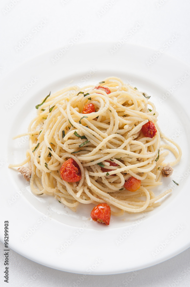 Spaghetti pasta with cherry tomatoes, basil and parmesan cheese, selective focus