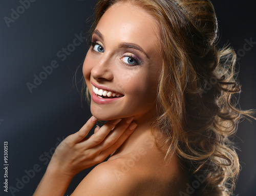 Beautiful woman with curly long hair on dark background