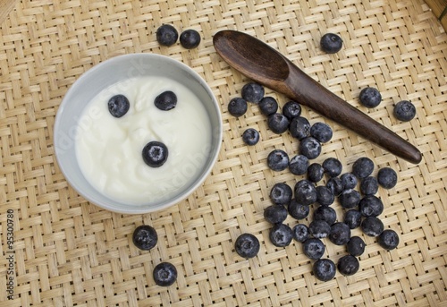 Yoghurt with whole fresh blueberries and wooden spoon