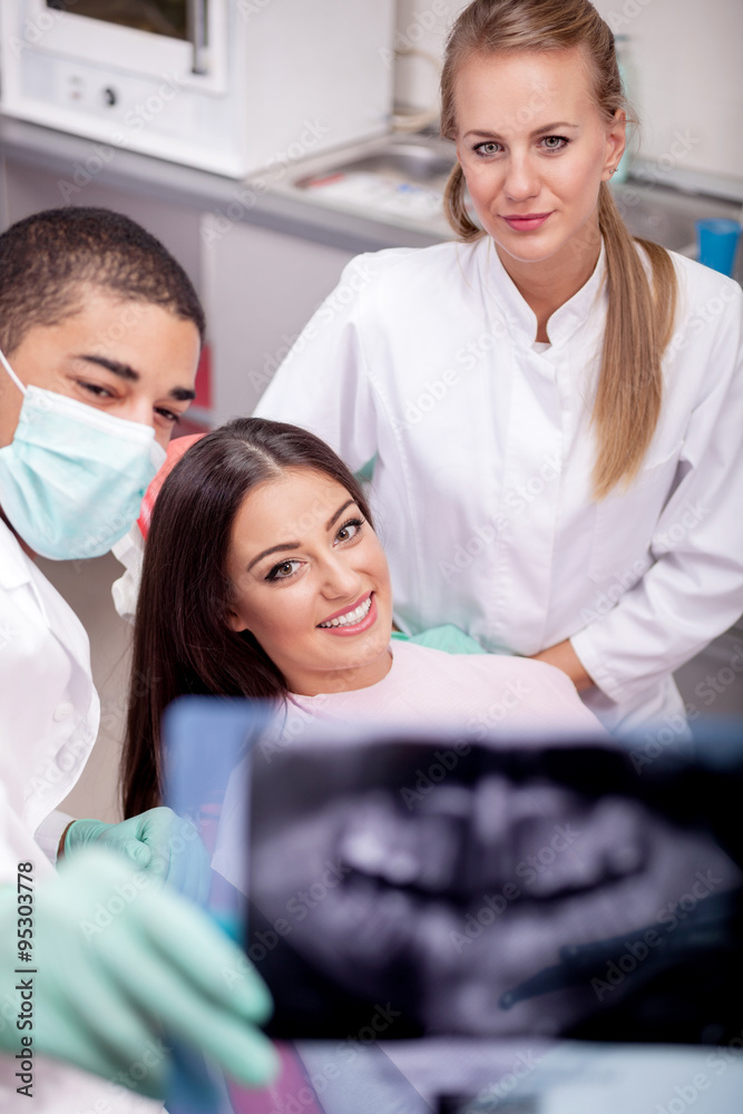 Dentist explaining the details of x-ray picture to his patient Dentist explaining the details of x-ray picture to his patient