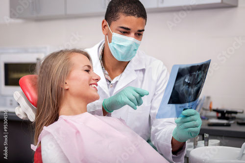 Dentist explaining the details of x-ray picture to his patient