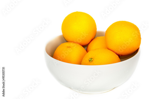 Orange fruit in white bowl on white background