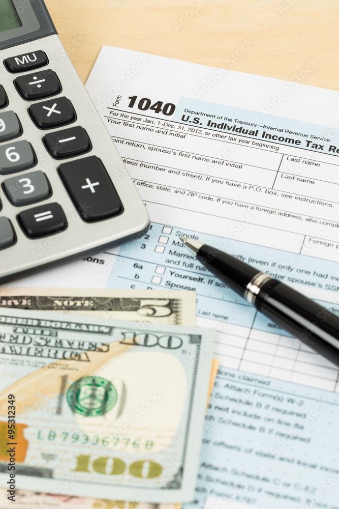 Tax form with banknote, calculator, and pen Tax form with banknote, calculator, and pen