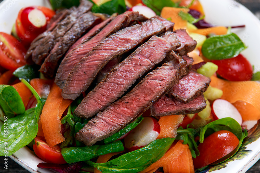 Spicy Beef Slices Meat Salad with Carrots, Tomatoes, Cucumber, Parsley and Salad leaves Spinach, rocket, red ruby chard
