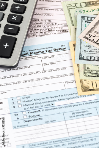 Tax form with calculator and banknote taxation concept