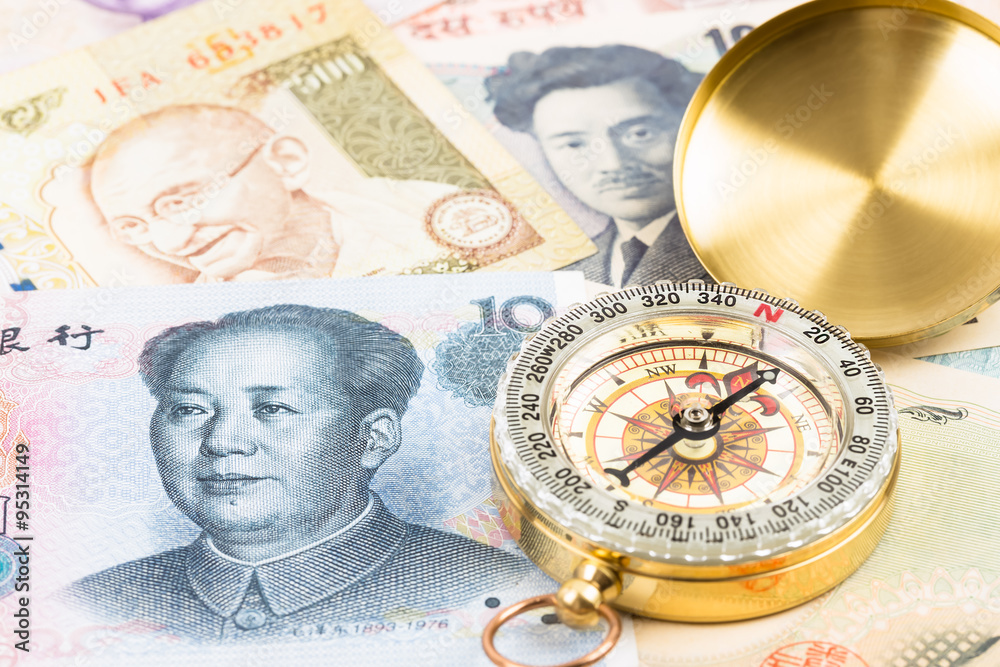 Compass on asian banknote concept financial direction Compass on asian banknote concept financial direction