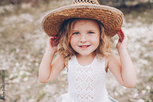 happy little girl wearing a hat outdoors