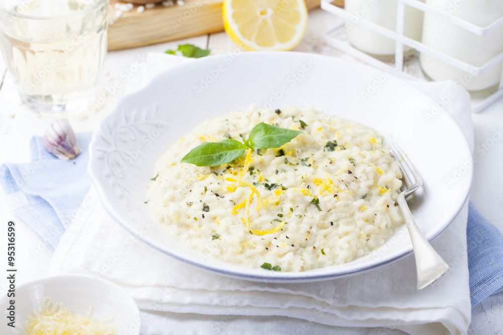 Risotto with lemon and fresh basil. White wooden background Risotto with lemon and fresh basil. White wooden background