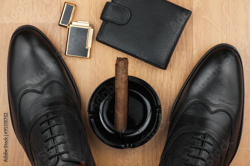 Male still life, classic men's shoes and a cigar in an ashtray