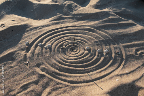 Conceptual sundial on the beach sand photo