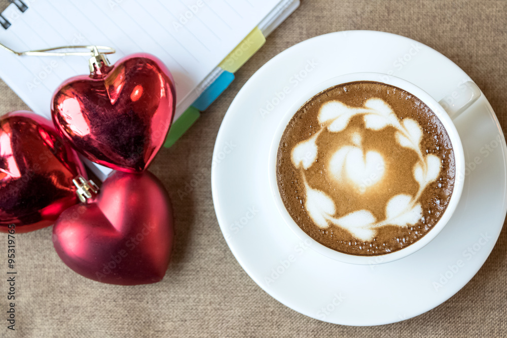 Hot coffee latte, latte art with red heart in white cup on a tab Hot coffee latte, latte art with red heart in white cup on a tab