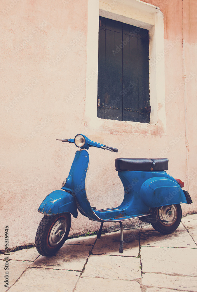Old scooter leaning against a wall in Italy