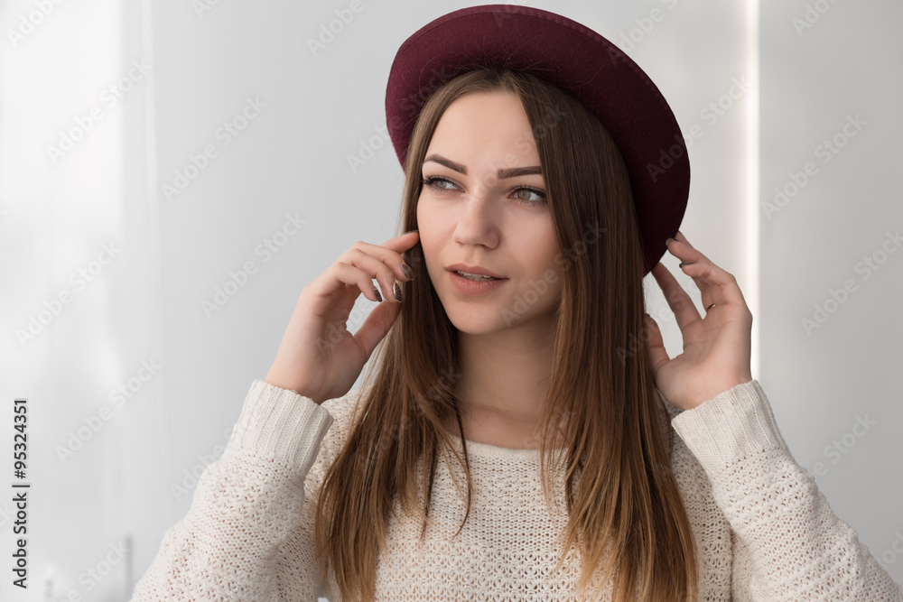 Fashionadle woman in hat. White wall background. Fashionadle woman in hat. White wall background.