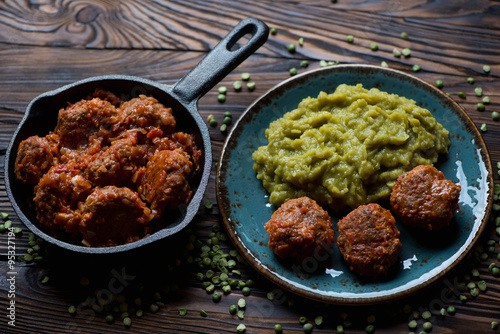Roasted meatballs with boiled peas on a rustic wooden surface