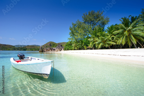 wooden boat on the beach with palms