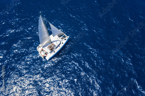 Amazing view to Catamaran cruising in open sea at windy day. Drone view - birds eye angle