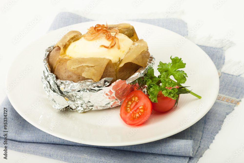 Baked potato with cheese in foliage with fresh tomato Baked potato with cheese in foliage with fresh tomato