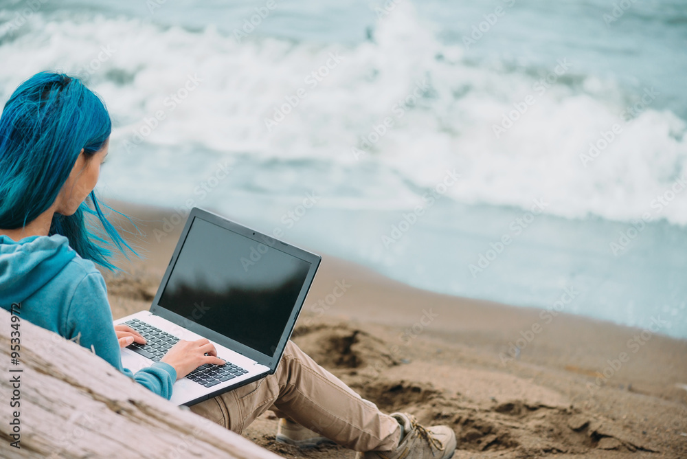 Freelancer girl working on laptop on coast