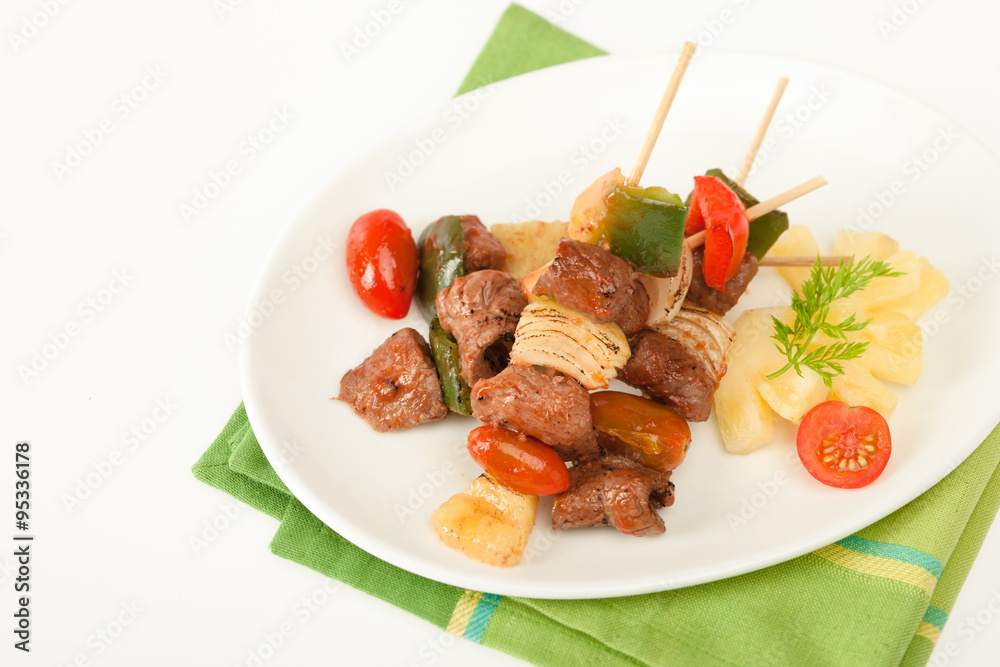 Fried barbeque meat on a bamboo sticks with vegetables