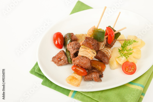 Fried barbeque meat on a bamboo sticks with vegetables