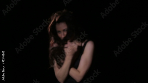 Young brunette in black party dress dancing, smiling, having fun and flirting