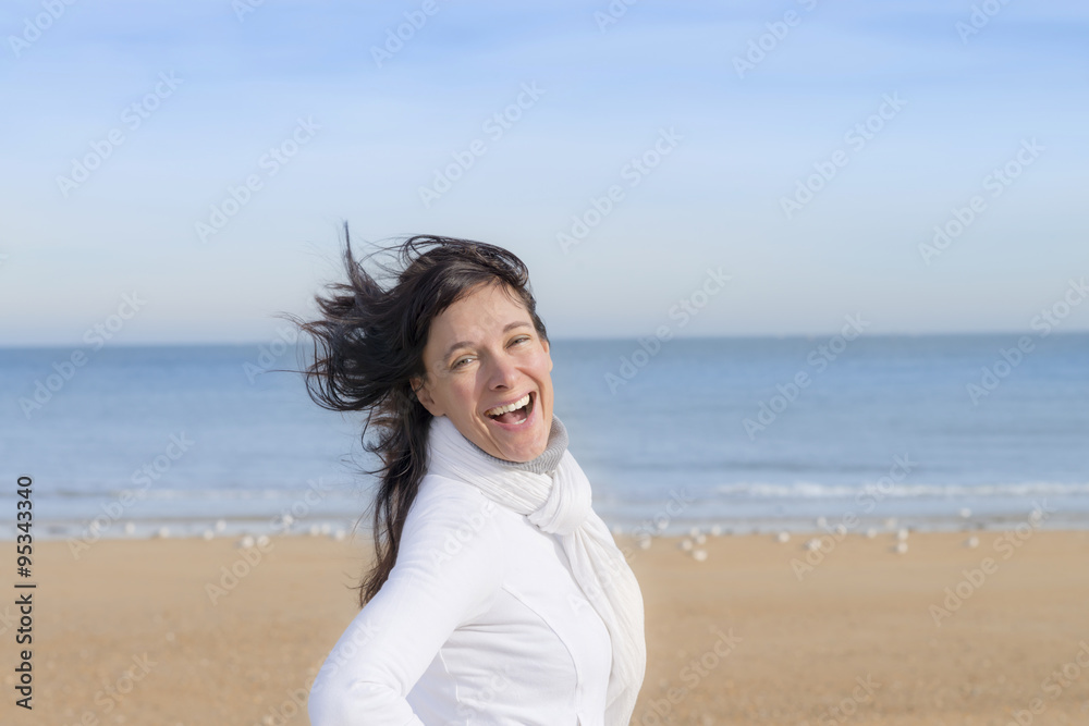Happy middle-aged woman smiling at the beach Happy middle-aged woman smiling at the beach