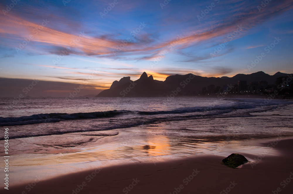 Sunset in Ipanema Beach in Rio de Janeiro, Mountains in the Horizon are Reflected in Wet Sand
