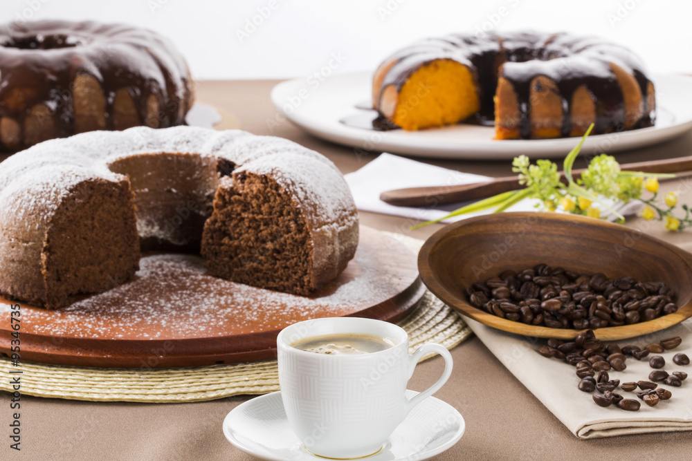 Chocolate cake on the table with carrot cake in the background. Chocolate cake on the table with carrot cake in the background.