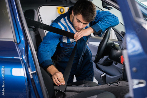 Portrait Of Mechanic Examining Car Seat Belt