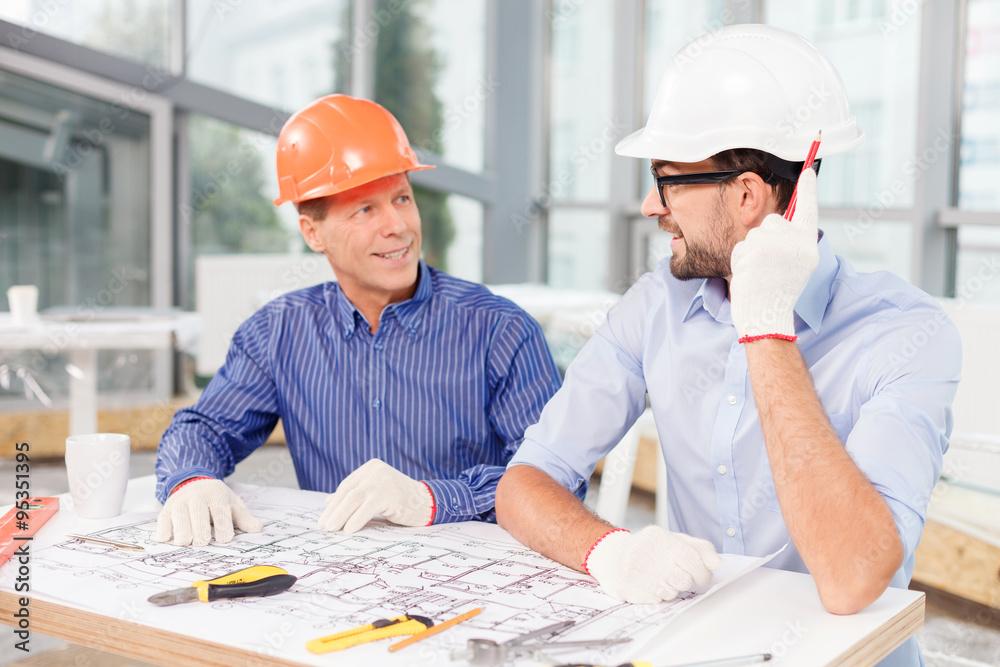 Professional two male architects working on a new project Professional two male architects working on a new project