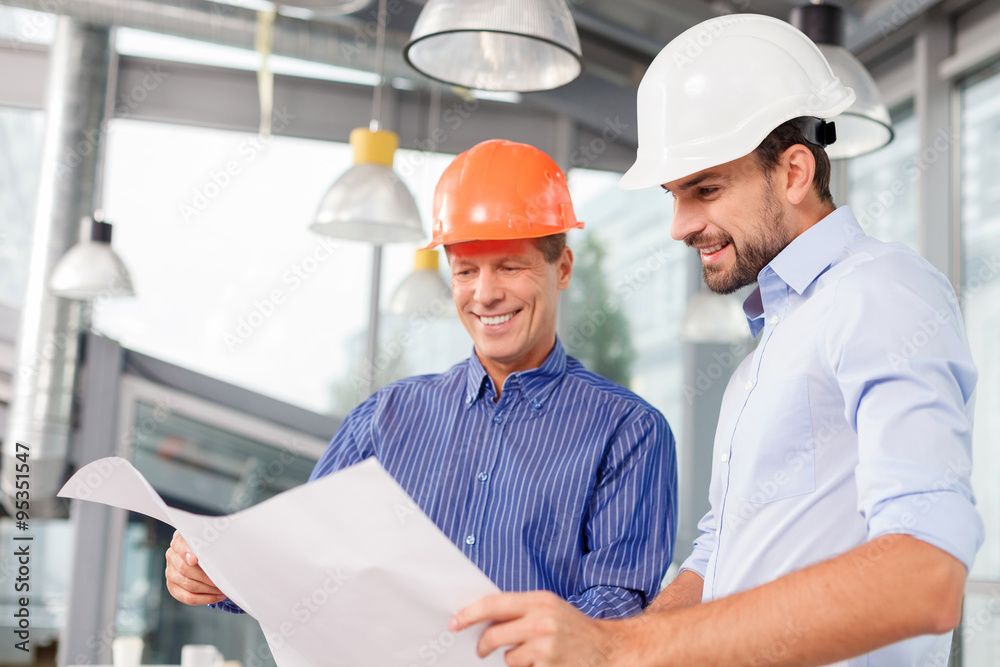 Cheerful male architects are discussing the new project Cheerful male architects are discussing the new project
