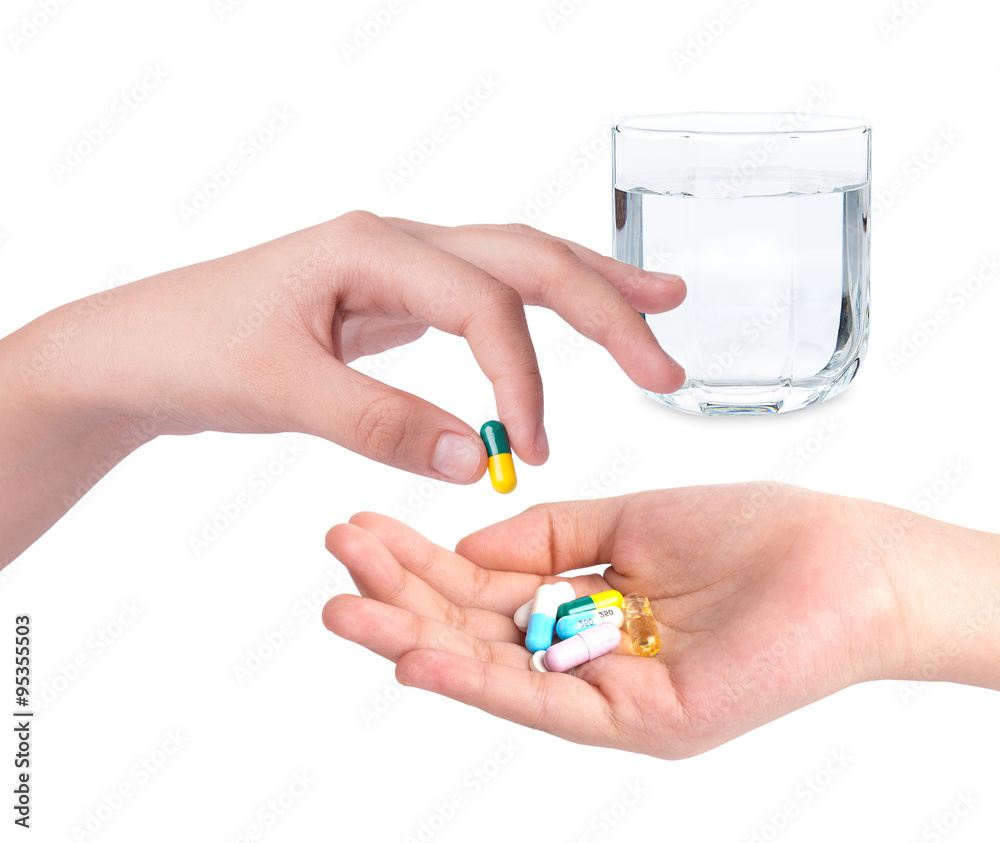 Drug capsules and pills in hand with drinking water Drug capsules and pills in hand with drinking water