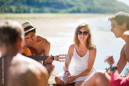 Teenagers having fun at the beach, are singing with guitare © jackfrog