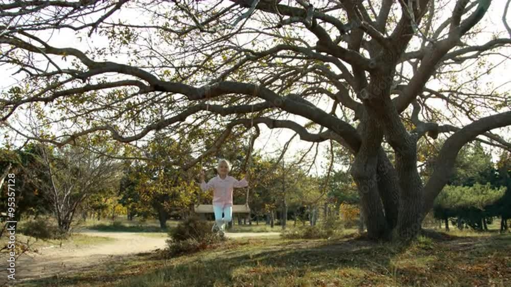 Child on a swing under a tree Child on a swing under a tree