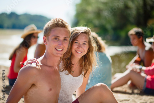 Focus on a good looking teenage couple sitting on the sand  © jackfrog