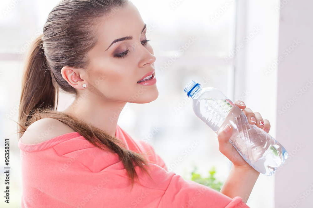 Portrait of confident young woman in sportswear holding a water bottle Portrait of confident young woman in sportswear holding a water bottle