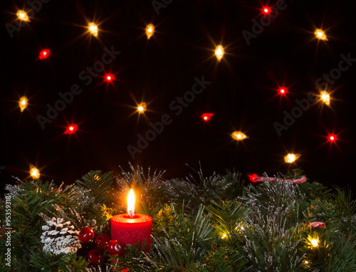 Christmas candle burning with evergreen and dark background  © tab62