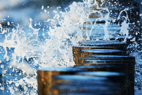 Wellen brechen sich an Buhnen im Meer photo