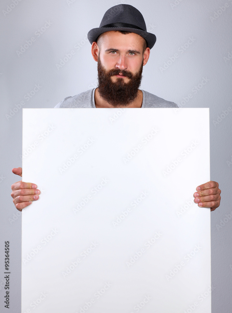 Portrait of young man in hat standing near blank, isolated on white background Portrait of young man in hat standing near blank, isolated on white background