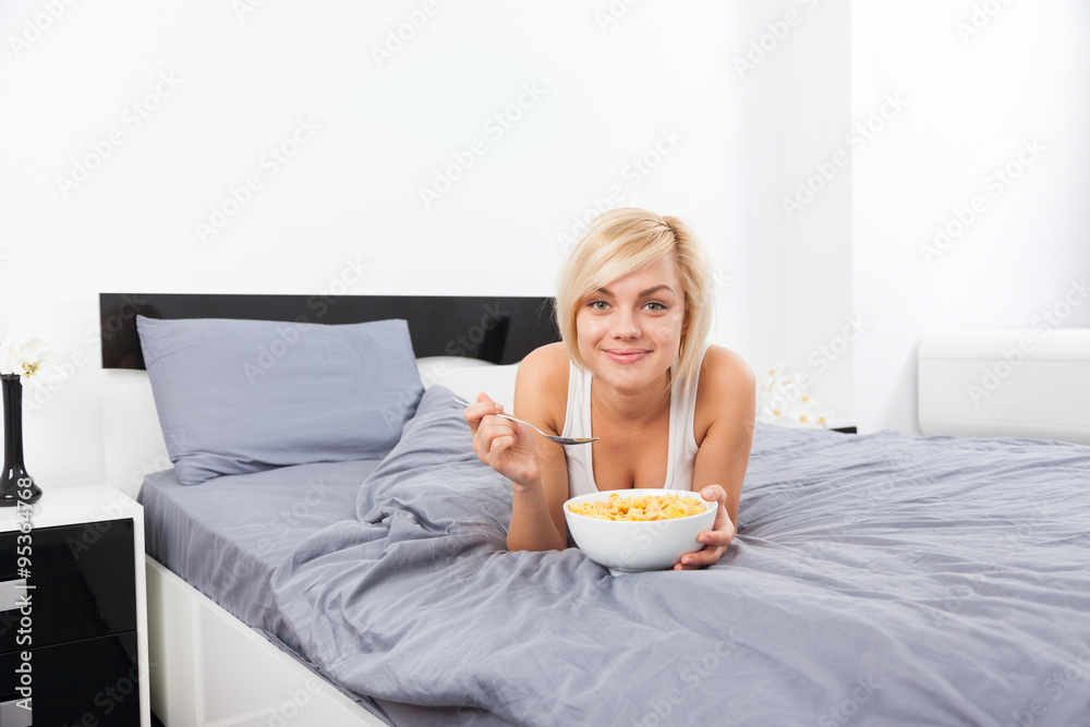 Breakfast in bed, young woman lying on bed Breakfast in bed, young woman lying on bed