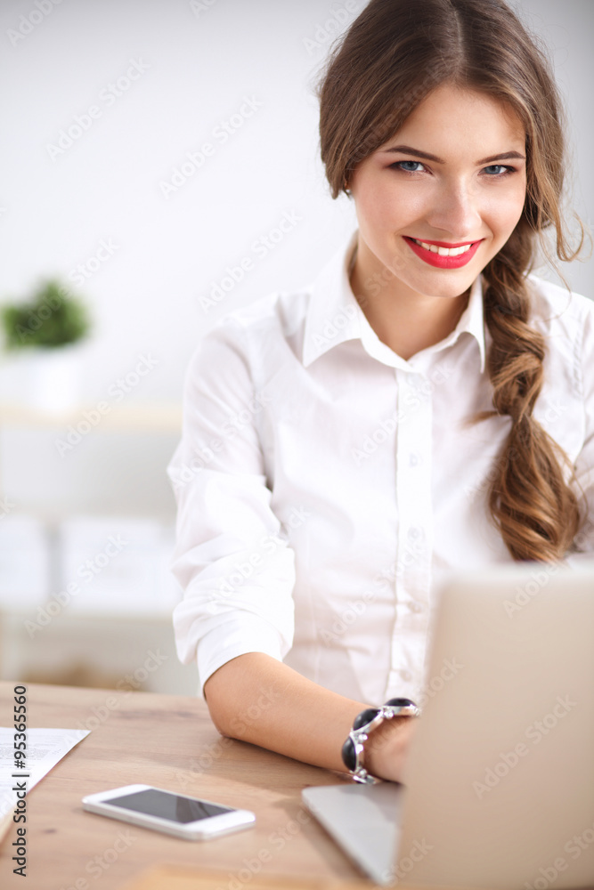 Attractive businesswoman sitting on desk in the office Attractive businesswoman sitting on desk in the office