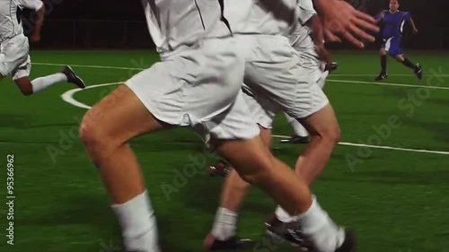 The camera pans with a soccer team as they score a goal